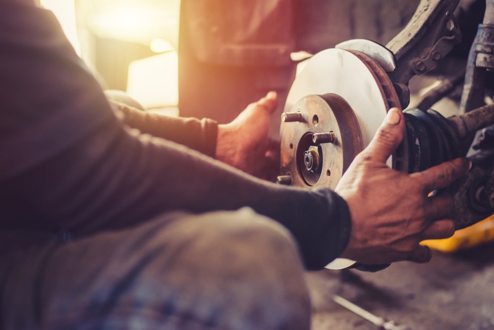 Mechanic working on car brakes for brake pad replacement in Chesterfield