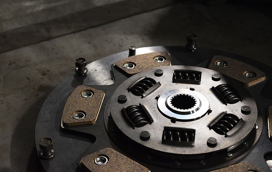 Mechanic inspecting engine bay before flywheel and clutch replacement